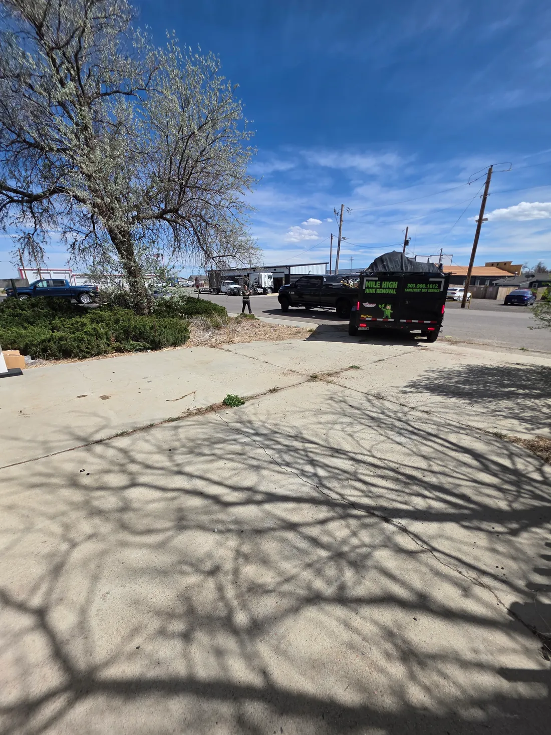 Cleared driveway with the Mile High Junk Removal trailer parked after a full junk removal cleanup in Denver