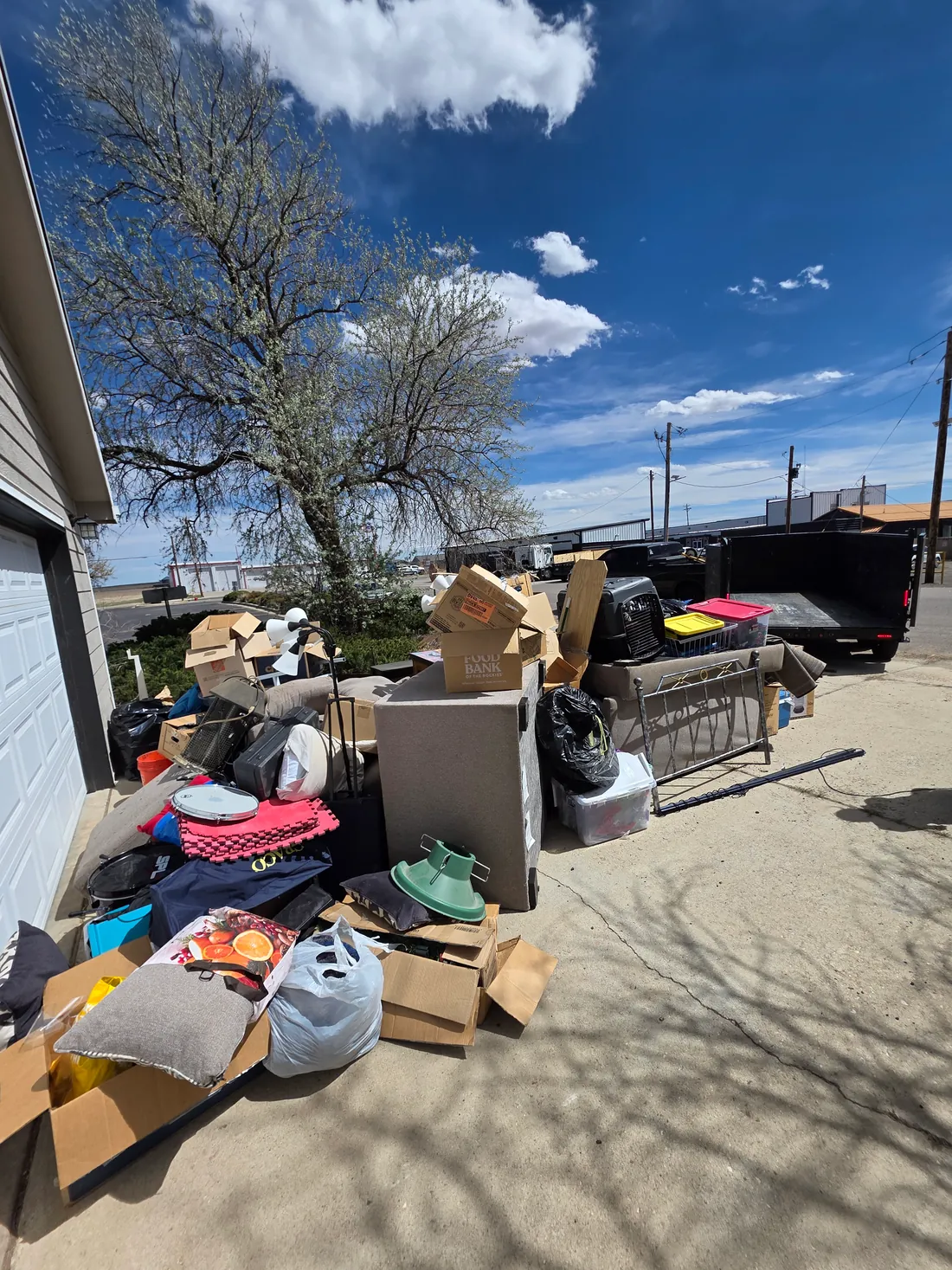 Driveway piled with furniture, boxes and household junk before a Mile High Junk Removal cleanup in Denver