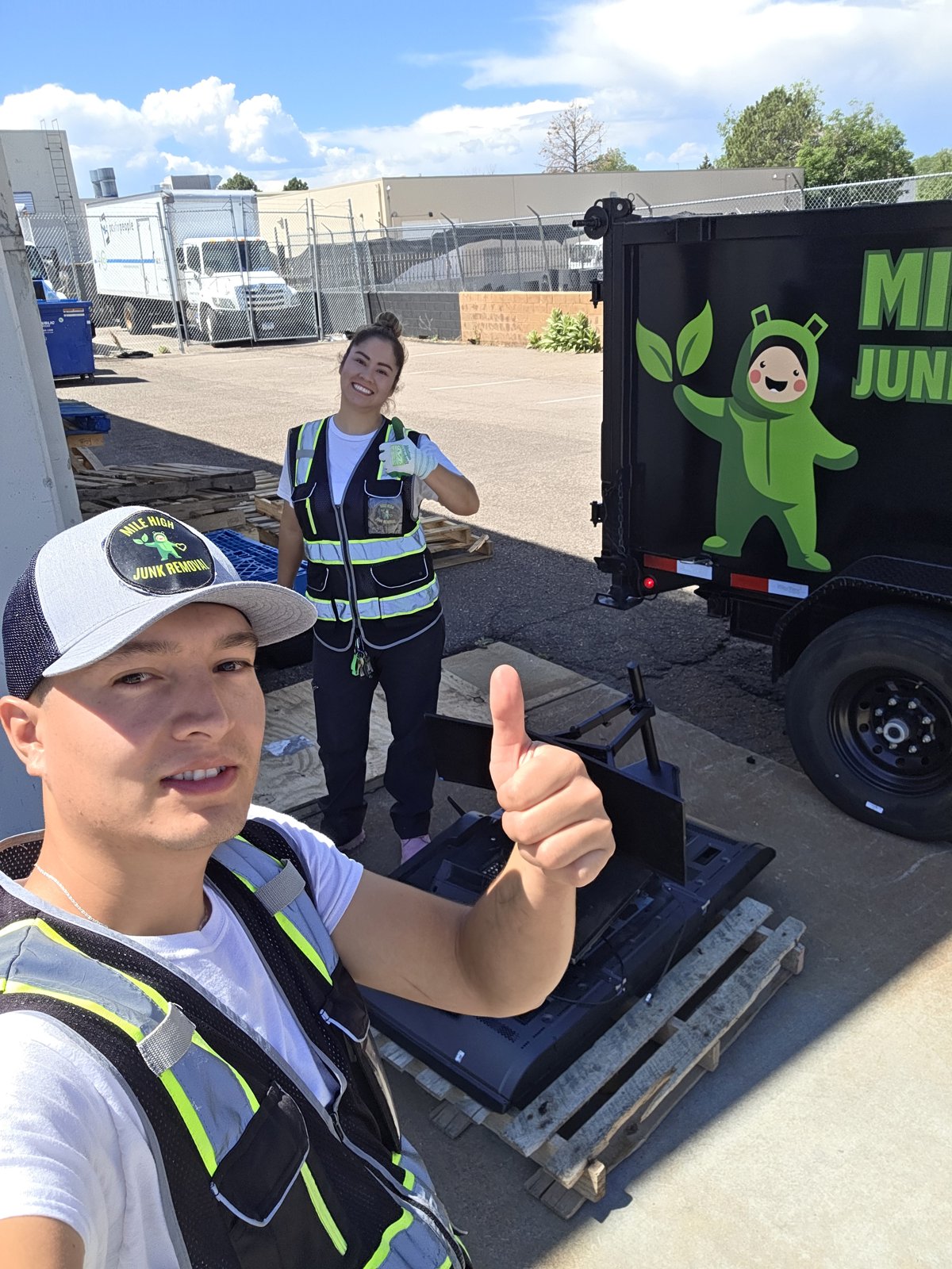 Mile High Junk Removal crew picking up an old TV for recycling