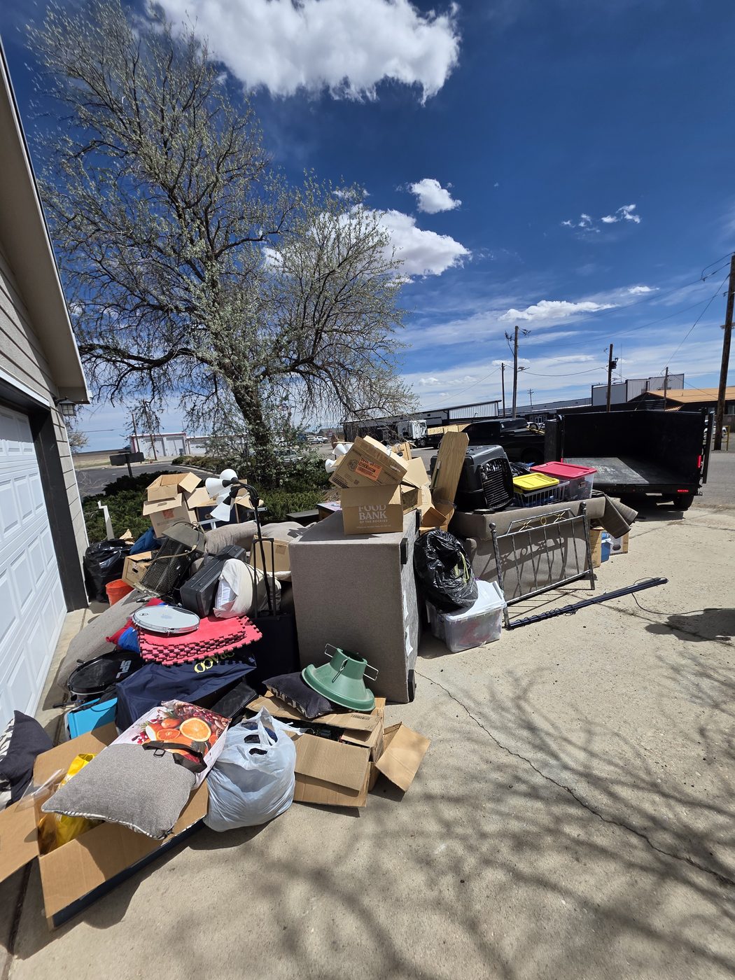 A curbside pile of furniture and boxes ready for a Denver junk removal pickup